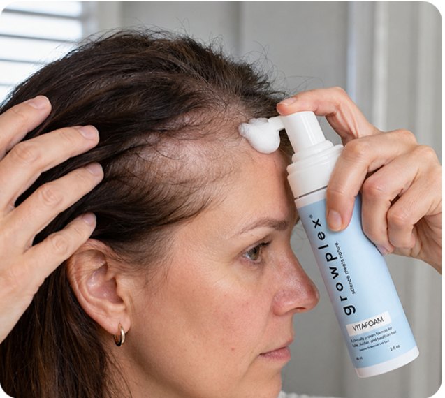 A woman applying Vitafoam to her part line